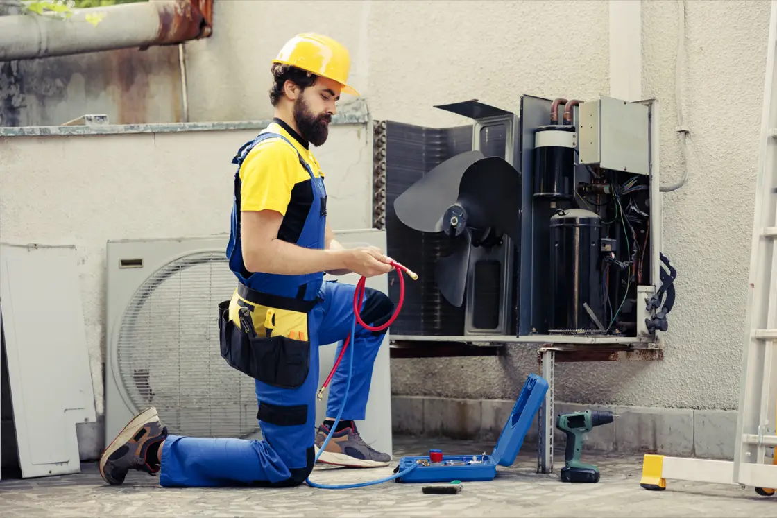 HVAC technician maintaining an air conditioning system for better indoor air quality